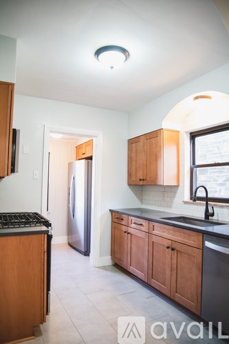 A kitchen with wooden cabinets and a black countertop.