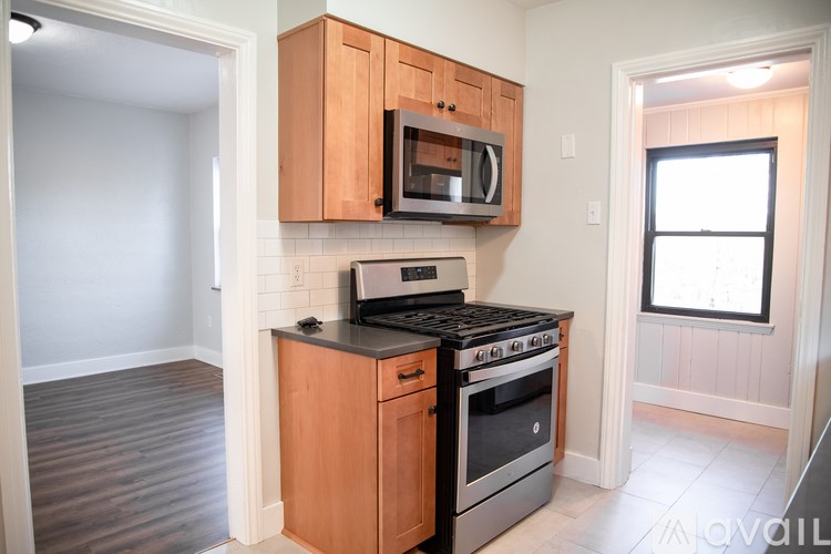 A kitchen with a stove and microwave.
