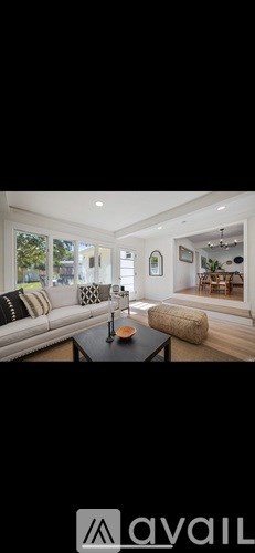 A modern living room with a white sofa and a coffee table.