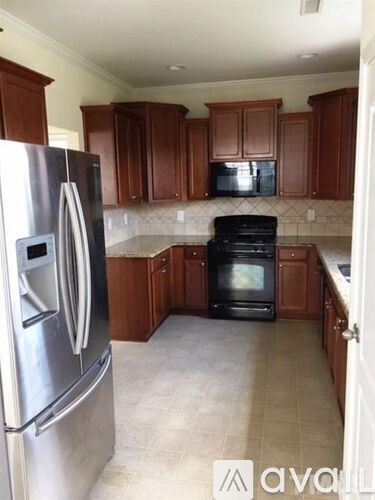 A kitchen with a stainless steel refrigerator and black oven.