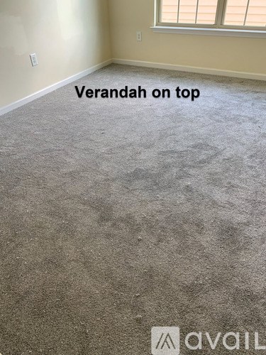 A room with carpet on the floor and a window on the wall.