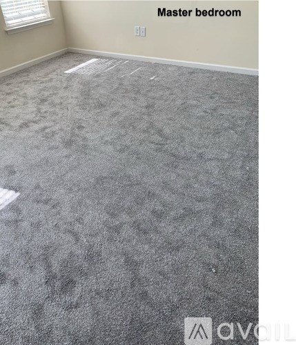 A carpeted room with a label "Master bedroom" on the wall.