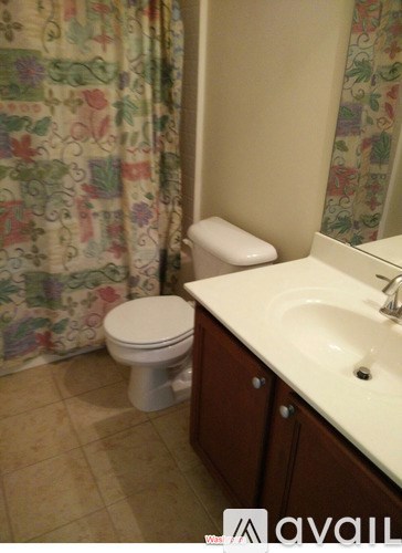 A white toilet sits in a bathroom next to a sink.