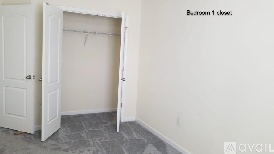 A white closet door is open, revealing a white interior.