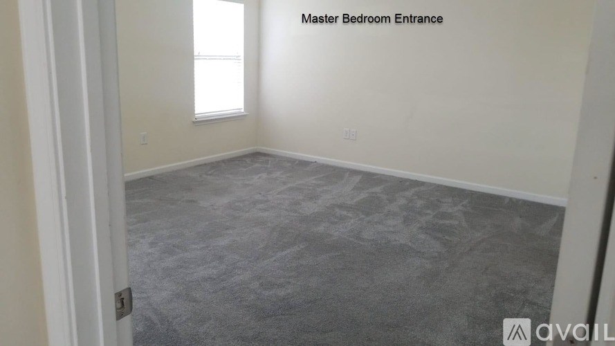 A room with a carpeted floor and a window.