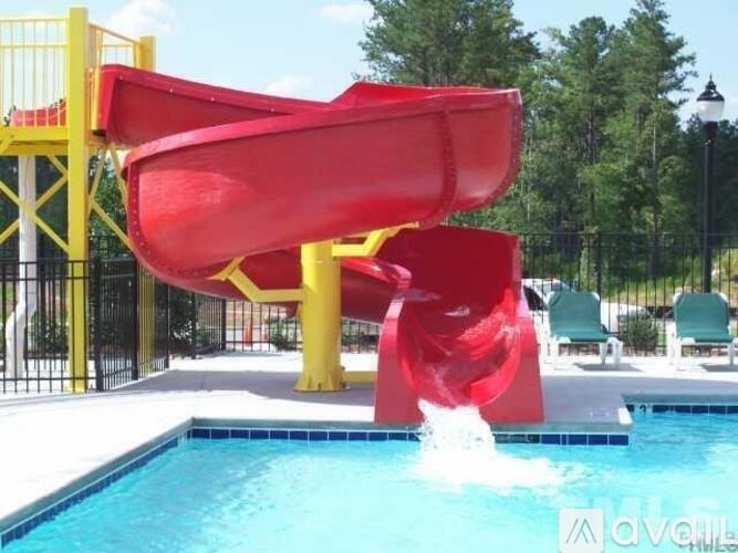 A red water slide in a pool.