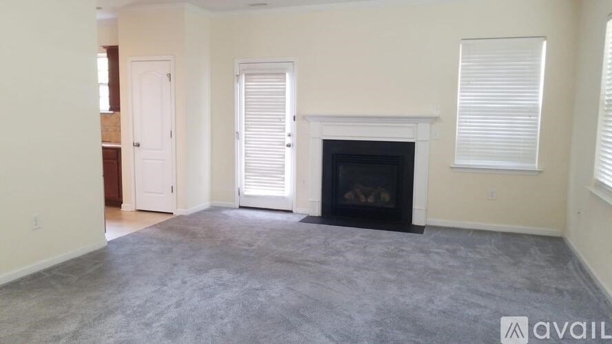 A living room with a fireplace and two doors.