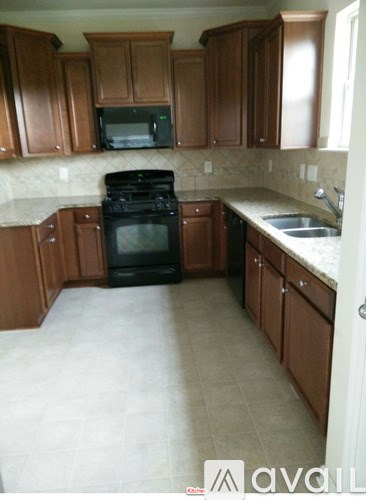 A kitchen with brown cabinets and a black oven.