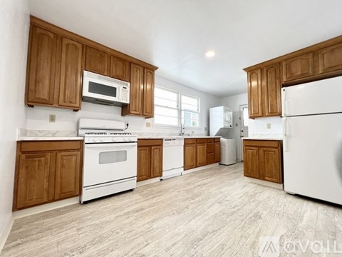 A kitchen with wooden cabinets and white appliances.