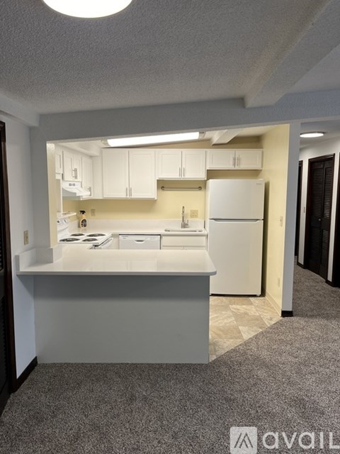 A kitchen with white cabinets and appliances.