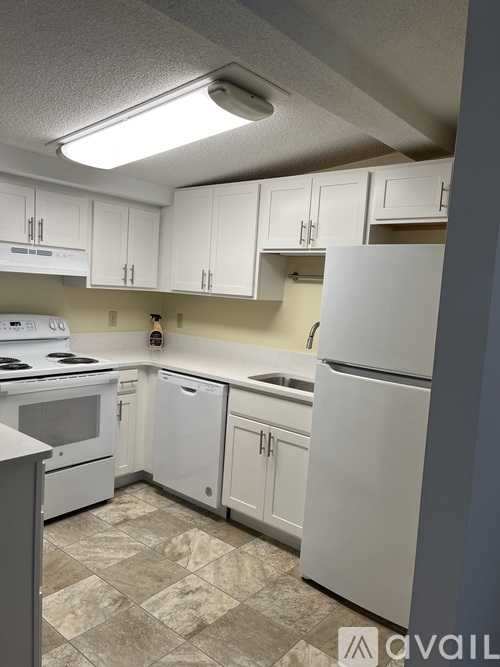 A kitchen with white appliances and cabinets.