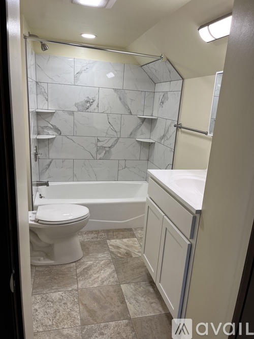 A bathroom with a toilet, sink, and bathtub.