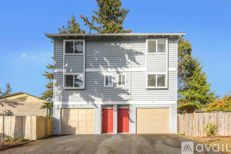 A two-story house with a red door is for sale.