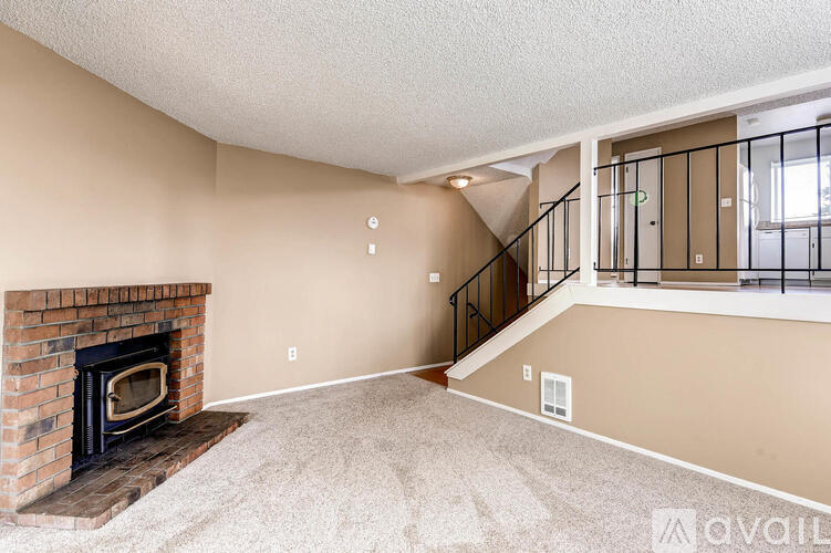 A living room with a fireplace and a staircase.