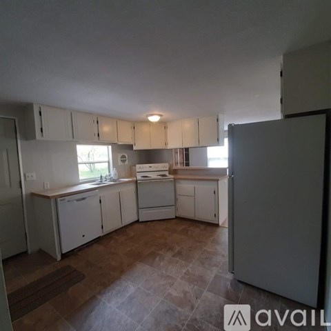 A kitchen with white cabinets and a tiled floor.