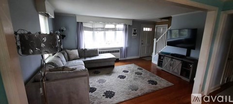 A living room with a couch and a television.