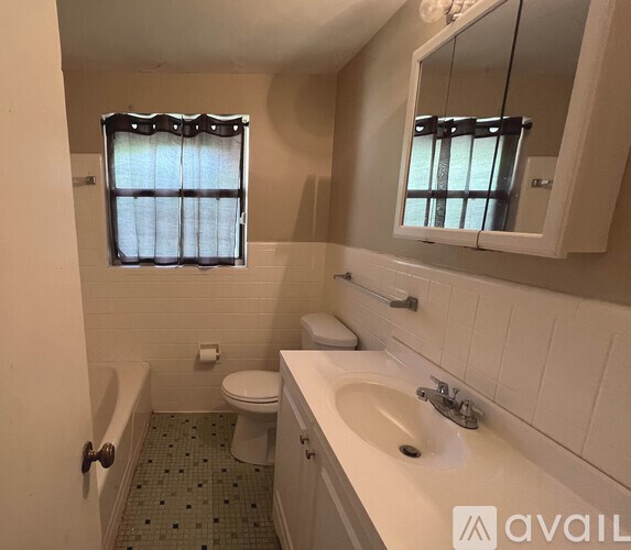 A bathroom with a toilet, sink, and bathtub.