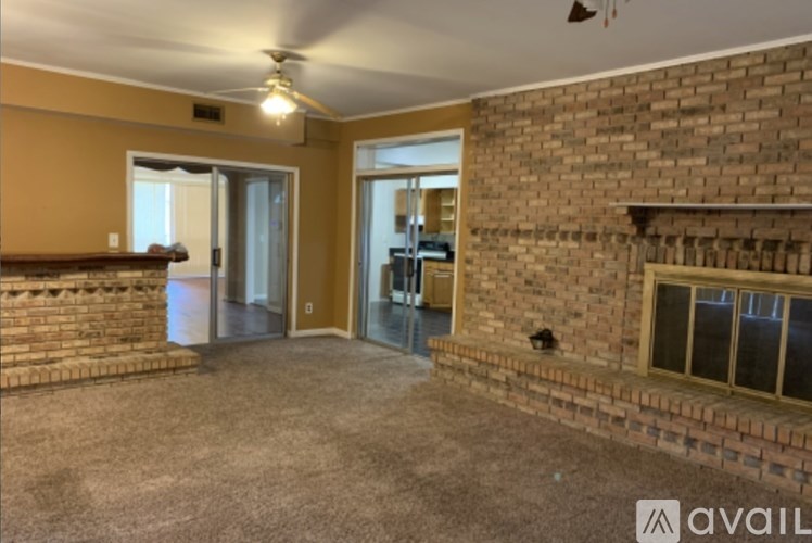 A living room with a brick wall and a carpeted floor.