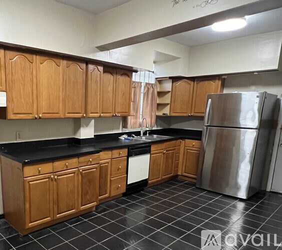 A kitchen with wooden cabinets and a black countertop.