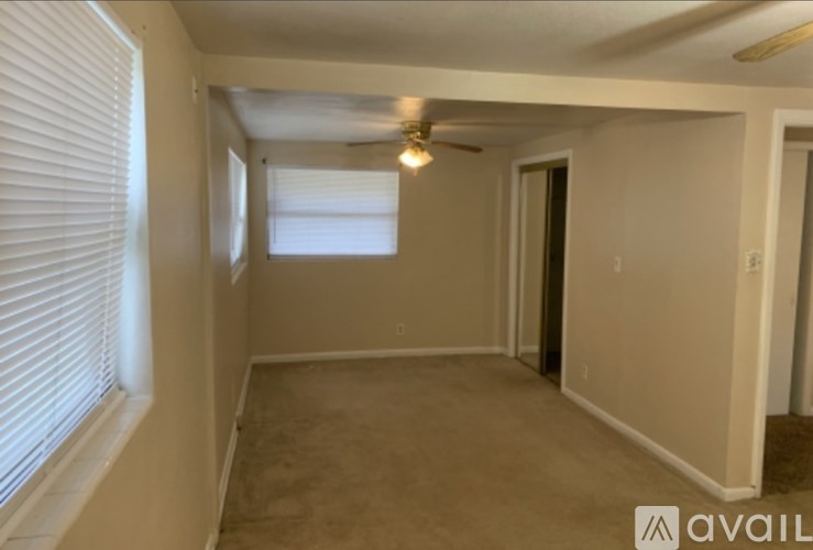 A room with a window, a door, and a ceiling fan.