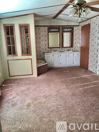 A room with a ceiling fan and floral wallpaper.