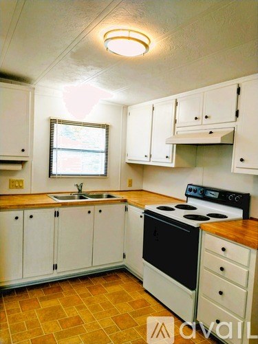 A kitchen with white cabinets and a black stove top oven.