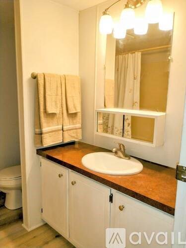 A bathroom with a towel hanging on the wall and a mirror above the sink.