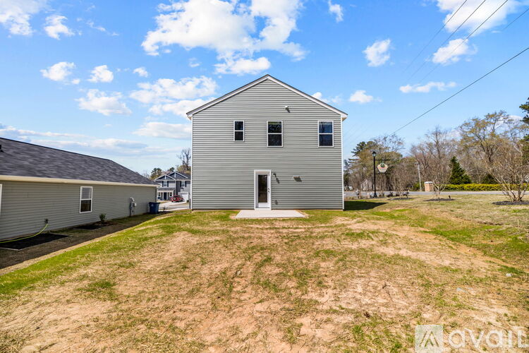 A two-story house with a garage is situated in a grassy area.