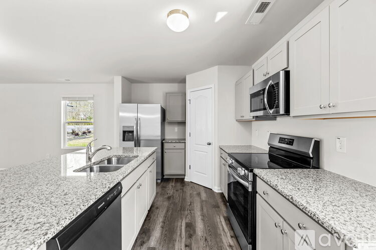 A kitchen with white cabinets and a granite countertop.