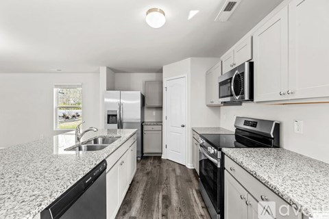 A kitchen with white cabinets and a granite countertop.