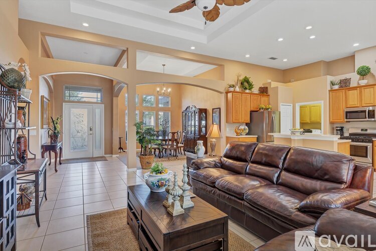A living room with a brown leather couch and a coffee table in the center.