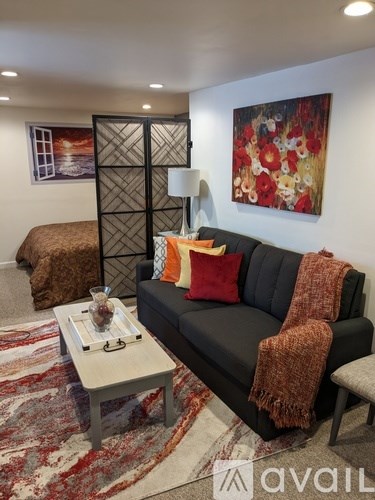 A living room with a black couch and a coffee table.