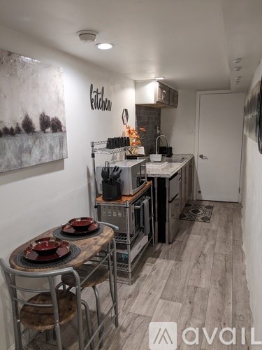 A kitchen with a table set for two and a painting on the wall.