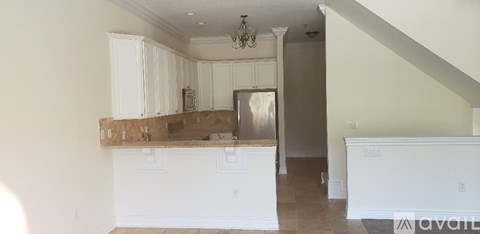 A kitchen with white cabinets and a counter top.