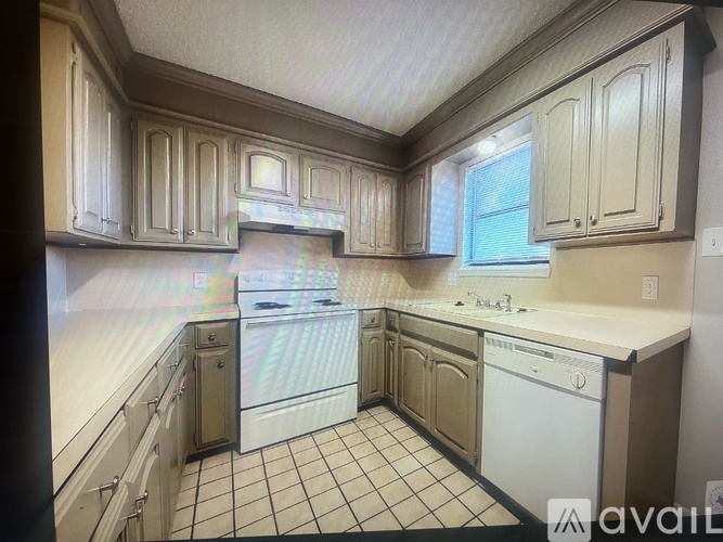 A kitchen with white appliances and cabinets.