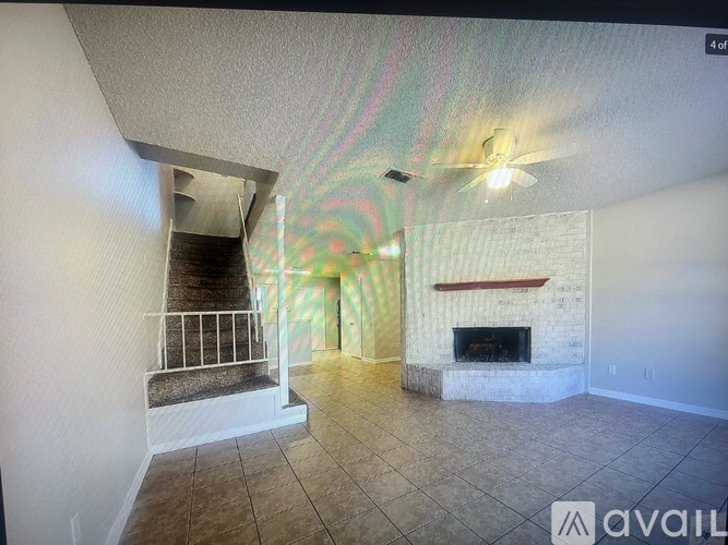 A living room with a fireplace and a staircase.