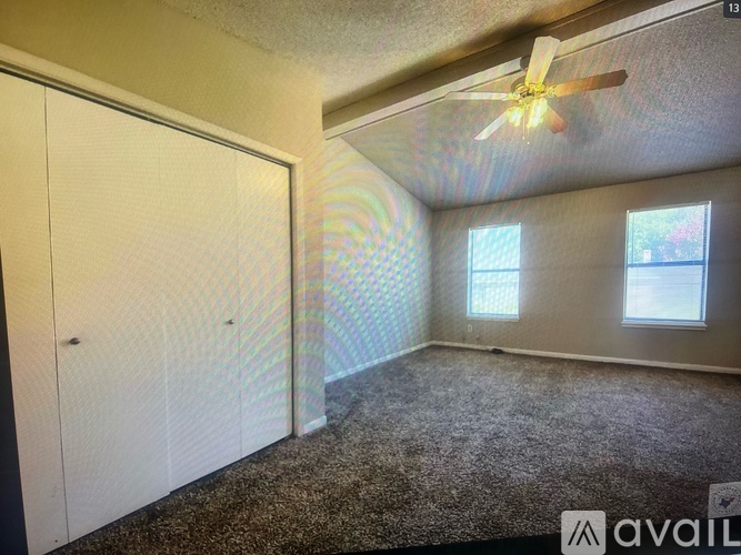 A room with a ceiling fan and a carpeted floor.