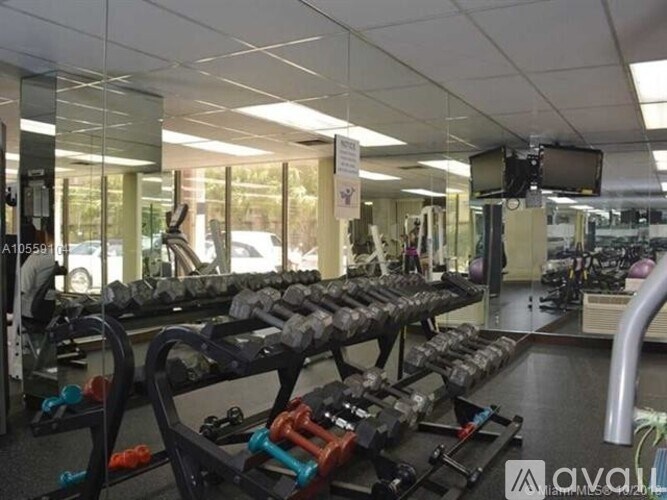 A gym with a variety of dumbbells and weight machines.
