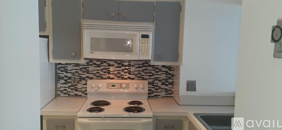 A kitchen with a white stove top oven and a microwave above it.