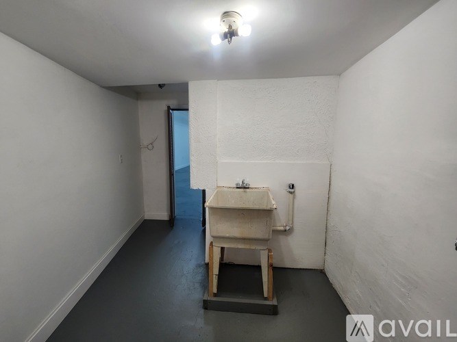 A room with a sink and a door in the background.