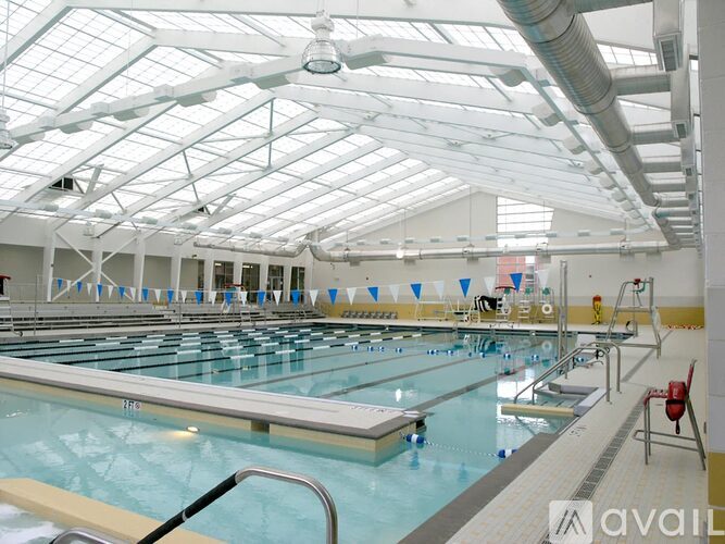 A large indoor swimming pool with multiple lanes and a diving board.