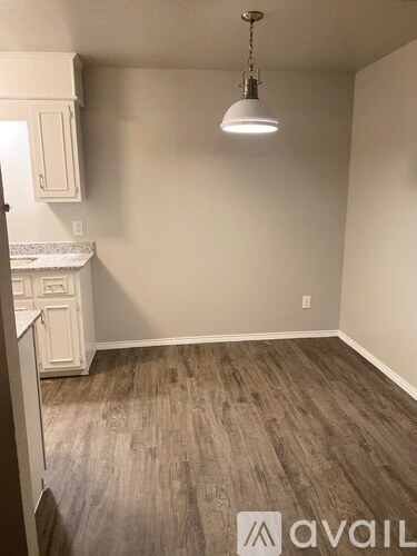 A room with a wooden floor and a hanging light fixture.