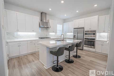A kitchen with white cabinets and a center island.