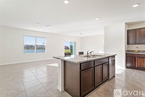 A spacious kitchen with a large island and brown cabinets.