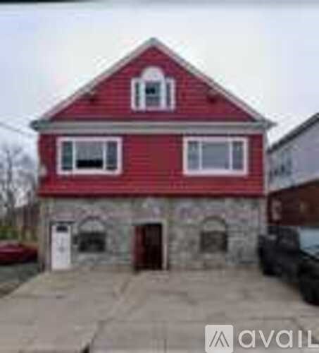 A red house with a stone foundation and a white door.