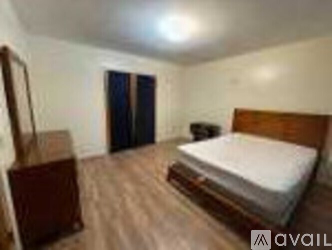 A bedroom with a bed, wardrobe, and a chair.
