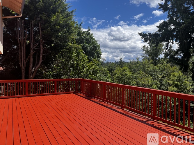 A wooden deck with a railing and trees in the background.