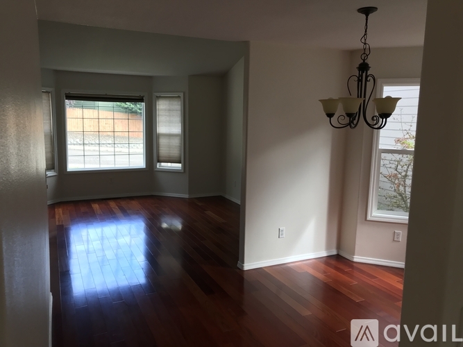 A room with wooden floors and a chandelier hanging from the ceiling.