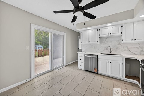 A kitchen with white cabinets and a marble backsplash is available for rent.
