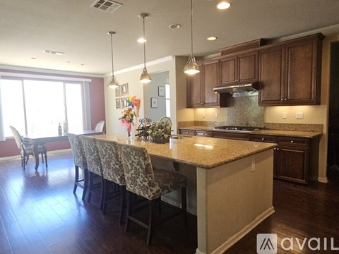 A kitchen with a table and chairs with a dog sitting at the table.